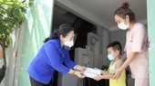 Chairwoman of the municipal People’s Council Nguyen Thi Le (L) hands over gifts to a family in Cu Chi District. (Photo: SGGP)