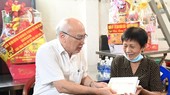 Head of the Propaganda and Education Board of the City Party Committee Phan Nguyen Nhu Khue (L) offers present to Ms. Luong Ha Nu. (Photo: SGGP)