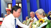 Chairman of the HCMC People’s Committee Phan Van Mai presents the "Vietnamese Heroic Mother" title to relatives of mothers. (Photo: SGGP)