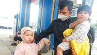 Anh Nguyễn Sửu cùng con đứng chờ xe khách vào Đồng Nai ngày 27-1 tại thị trấn Nghèn, huyện Can Lộc, Hà Tĩnh