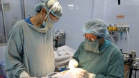 Bác sĩ Nguyễn Văn Đẩu (bìa phải) đang vá lại nụ cười cho trẻ sứt môi, hở vòm