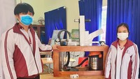 Hà và An bên máy hút dịch chanh dây bán tự động do 2 em thiết kế