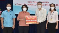 Chairwoman of the Vietnam Fatherland Front of HCMC, To Thi Bich Chau receives a cash assistance of the Party Committee of the banking sector in HCMC . (Photo: SGGP)