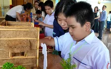 Học sinh Trường Phổ thông đặc biệt Nguyễn Đình Chiểu trải nghiệm sờ, chạm vào các mô hình sân khấu của câu chuyện "Sự tích trái thơm" tại chương trình. Ảnh: THÚY BÌNH
