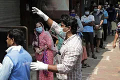 Shoppers wait for their turn to enter a grocery store in Mumbai on March 26. The nationwide lockdown has squeezed the supply of essential items such as food and medication. © AP