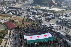 Người dân ăn mừng khi cầm lá cờ đối lập Syria lớn tại Quảng trường Umayyad ở Damascus vào ngày 9/12/2024. (OMAR HAJ KADOUR / AFP)