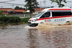 Xe cứu thương chạy qua vùng nước lũ sau khi trận mưa lớn gây ngập lụt khu vực quận Miyun, Bắc Kinh