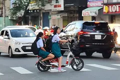 Học sinh chạy xe điện nhưng không đội nón bảo hiểm. Ảnh: ĐOÀN HIỆP