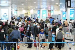 Hành khách tuân thủ việc đeo khẩu trang khi làm thủ tục chuyến bay tại Cảng hàng không quốc tế Nội Bài. (Ảnh: Phan Công/Vietnam+)