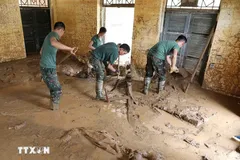 Lực lượng quân đội thu dọn bùn đất tại điểm trường mầm non Suối Lư, Điện Biên. (Ảnh: Trung Kiên/TTXVN)