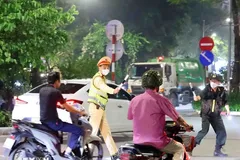 Cán bộ, chiến sỹ thuộc tổ công tác liên ngành Y6/141 dừng xe kiểm tra và xử lý 1 trường hợp vi phạm giao thông. (Ảnh: Phạm Kiên/TTXVN)