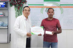 BS.CKII Chung Tấn Định trao tiền hỗ trợ của các mạnh thường quân cho cha của bé T.