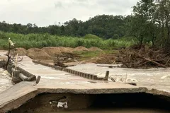 Đường dẫn vào làng Hrách, xã Sró bị nước lũ chia cắt, hiện các phương tiện không thể qua lại, người dân chỉ có thể lội suối