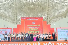 Phó Thủ tướng Trần Hồng Hà (thứ 8 từ phải sang) và Thứ trưởng Bộ Xây dựng Nguyễn Văn Sinh (thứ 9 từ phải sang) trao giấy chứng nhận sản phẩm xuất sắc cho doanh nghiệp tham gia triển lãm.