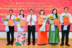 Giám đốc Nguyễn Toàn Thắng trao quyết định và tặng hoa chúc mừng cho cán bộ thuộc hệ thống VPĐKĐĐ TPHCM. Ảnh: Việt Dũng