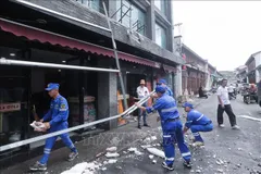 Công nhân tháo dỡ các bảng hiệu bị gió thổi bay tại tỉnh Chiết Giang, Trung Quốc. Ảnh: THX/TTXVN