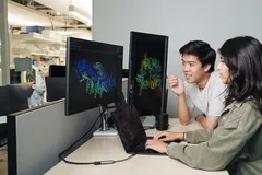 Brian Hie và Aditi Merchant đang xem xét cấu trúc protein được tạo ra bởi Evo 2, một công cụ AI có khả năng đề xuất các thiết kế bộ gen. Ảnh: Stanford Report