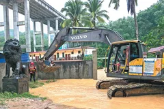 Lực lượng cứu hỏa sử dụng máy xúc để giải cứu 14 người bị mắc kẹt do nước lũ tại Ngũ Chỉ Sơn, tỉnh Hải Nam, vào hôm 14-9. Ảnh: China Daily