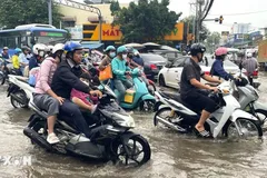 Nước dâng sớm, rút chậm trên đường Phạm Hữu Lầu, kéo dài từ cầu Phước Long đến đường Huỳnh Tấn Phát (Thành phố Hồ Chí Minh) khiến các phương tiện di chuyển chậm, khó khăn. (Ảnh: Hương Giang/TTXVN)