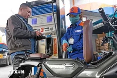 Mua, bán xăng tại điểm kinh doanh xăng dầu. (Ảnh: Trần Việt/TTXVN)