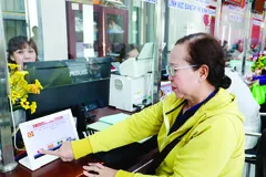 Người dân đánh giá sự hài lòng với sự phục vụ của công chức Trung tâm Phục vụ hành chính công xã Bà Điểm. Ảnh: Ngô Bình