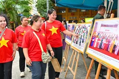 Người dân phường Bến Thành tham quan triển lãm ảnh về những thành tựu kinh tế - xã hội, quốc phòng an ninh. ẢNH: MẠNH THẮNG