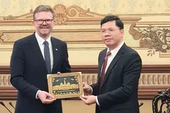Vice Chairman of the Ho Chi Minh City People’s Committee Hoang Nguyen Dinh (R) presents a souvenir gift to the South Australian Minister for State Development, Chris Picton. (Photo: SGGP)