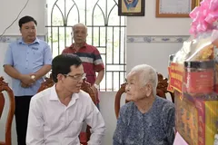 Head of the Municipal Party Committee's Inspection Commission Duong Trong Hieu, visits Vietnamese Heroic Mother Tran Thi Hien. (Photo: SGGP)
