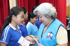 A representative of the Ho Chi Minh City Women's Charity Association presents scholarships to high-achieving students from disadvantaged backgrounds. (Photo: SGGP)