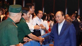Prime Minister Nguyen Xuan Phuc (R) greets participants in the programme in Hanoi on October 17 (Photo: VNA)