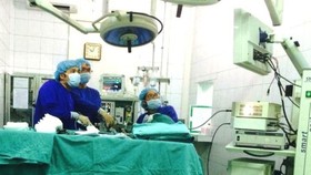 Medical workers perform an operation to treat hemorrhoids (Photo: SGGP)