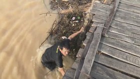 Mưa lớn, hàng chục người dân chèn chống để giữ cầu ván sông Trà Bồng