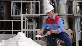 Anh Hà Trầm Huy kiểm tra độ khô của muối được sấy từ nguồn năng lượng thu hồi trong sản xuất
