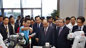 Prime Minister Nguyen Xuan Phuc (front, third, right) visits an exhibition on the sidelines of the forum on vocational training in Hanoi on November 16 (Photo: VNA)