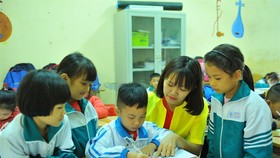 A teacher and first graders at Cuc Phuong Primary School in the northern province of Ninh Binh's Nho Quan District during a mathematics class. (Photo: VNA/VNS)
