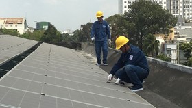Nhân viên ngành điện lắp đặt điện mặt trời áp mái cho một đơn vị trên địa bàn TPHCM