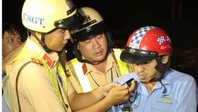 Kiểm tra nồng độ cồn người điều khiển phương tiện giao thông. Ảnh: TUẤN VŨ