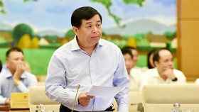Bộ trưởng Bộ KH-ĐT Nguyễn Chí Dũng trình bày báo cáo về kinh tế - xã hội. Ảnh: TTXVN