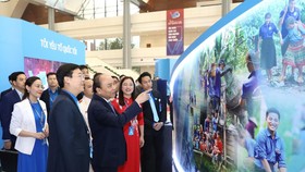 Thủ tướng Nguyễn Xuân Phúc với các đại biểu tham quan Triển lãm “Tôi yêu Tổ quốc tôi” tại Đại hội. Ảnh: TTXVN