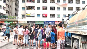 Người dân tại nhiều khu vực ở Hà Nội phải xếp hàng chờ lấy nước từ xe bồn vì nước sạch sông Đà nhiễm mùi lạ. Ảnh: QUỐC KHÁNH