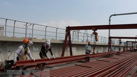 Công nhân thi công đường ray tuyến metro số 1 tại ga Phước Long. (Ảnh: Tiến Lực/TTXVN)
