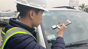 Nhân viên VETC thực hiện dán thẻ e-tag lên ô tô. Ảnh: VGP/Phan Trang.