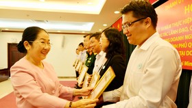 Phó Bí thư Thành ủy Võ Thị Dung tặng bằng khen cho các cá nhân tại hội nghị tổng kết 10 năm thực hiện Chỉ thị 22-CT/TW của Ban Bí thư. Ảnh: VIỆT DŨNG