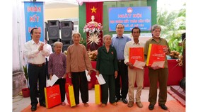 Đồng chí Nguyễn Thiện Nhân và đồng chí Ngô Sách Thực tặng quà cho bà con ở ấp Phú Mỹ, xã Phú Túc, huyện Châu Thành, tỉnh Bến Tre. Ảnh: HÀM LUÔNG