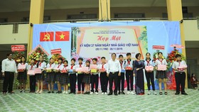 Ban đại diện hội phụ huynh học sinh Trường THCS Nguyễn Trãi quận Bình Tân và đại diện các nhà tài trợ tặng học bổng và quà cho các em học sinh nghèo hiếu học.