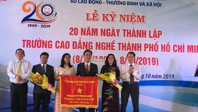 Ông Lê Minh Tấn, Giám đốc Sở LĐTB-XH TPHCM ( ngoài cùng bên trái) đại diện UBND TPHCM trao bức trướng của UBND TPHCM cho Ban Giám hiệu nhà trường