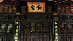A horizontal lacquered board engraved with characters , “Hoa Dung”, is hung over a door aiming at teaching the family’s members to live in peace with each other.