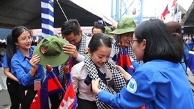 Members of the Ho Chi Minh Communist Youth Union welcome international friends. (Photo: VNA)