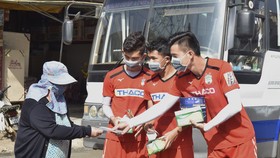 Các cầu thủ HAGL nhiệt tình phát khẩu trang miễn phí cho người dân phố núi. Ảnh: ANH TIẾN