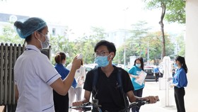 Đo thân nhiệt cho thí sinh. Ảnh: QUANG PHÚC